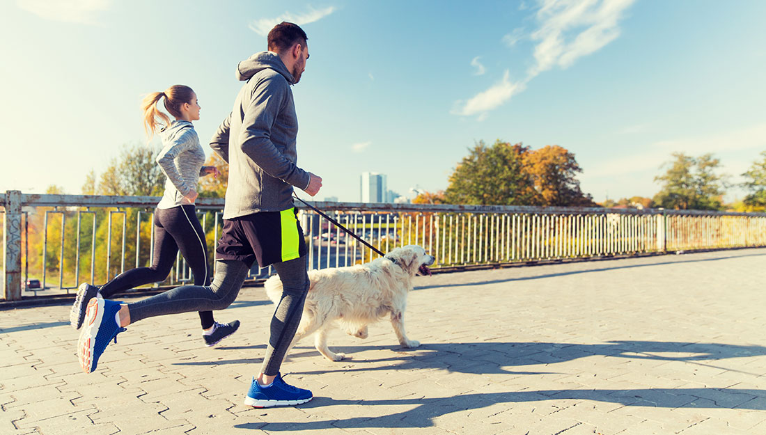 Couple qui court avec un chien