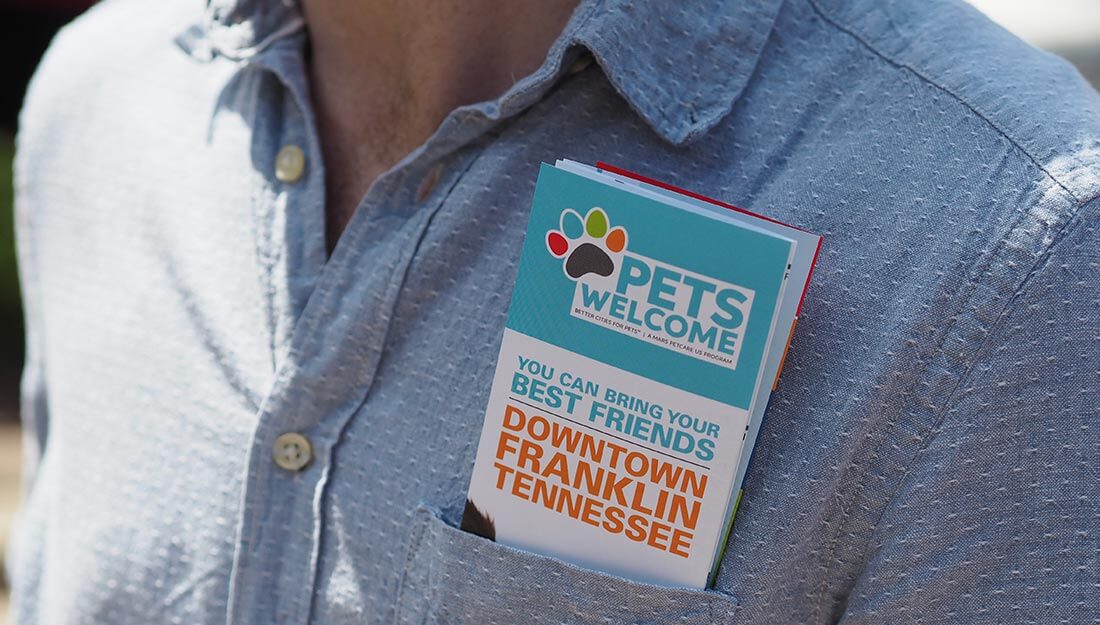 A Pets Welcome map sticking out of someone's pocket