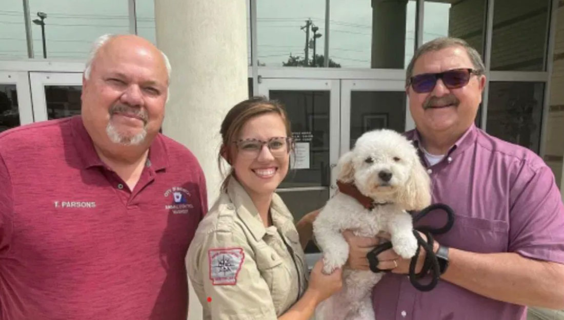 Sur cette photo de la ville de Benton, Terry Parsons, directeur des services aux animaux ; Mallori Howard, coordonnatrice des services d'adoption ; et le maire Tom Farmer posent avec un chien blanc moelleux nommé Bruno, qui a été sauvé par Tom et sa femme en 2019.