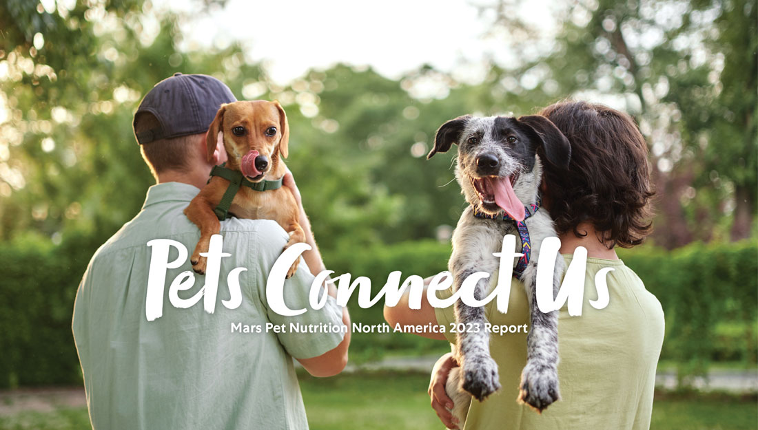 Two people holding dogs standing together at a park. On top of the image is the name of the Mars Pet Nutrition 2023 Annual Report: Pets Connect Us.
