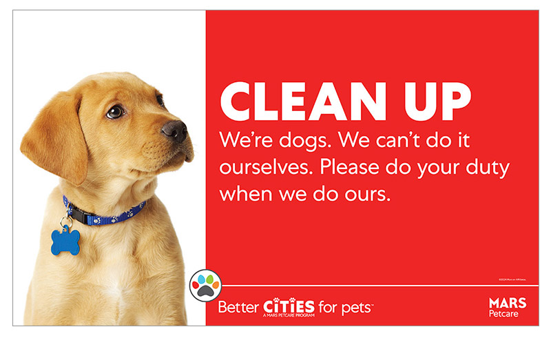 Un panneau indiquant la propriété responsable d'un animal de compagnie indique : "Nettoyez. Nous sommes des chiens. Nous ne pouvons pas le faire nous-mêmes. S'il vous plaît, faites votre devoir lorsque nous faisons le nôtre." Le panneau est simple et audacieux et comprend un joli chiot regardant le texte.