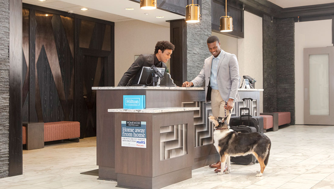 Un homme s'enregistrant dans un hôtel Homewood Suites avec son chien