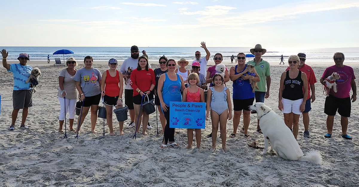 Daytona Beach residents stand with pets on the beach following a beach clean up event|A view of Daytona Beach|People with dogs sit on the rooftop bar at Streamline Hotel in Daytona Beach|Representatives of Nauti Pets and Daytona Dog Beach