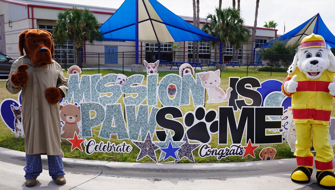 Banner from Mission pet event that reads "Mission is pawsome"|Dog on leash at public event in Mission|Woman hugging dogs at park|Mayor Dr. Armando O’Caña holding a dog|The Mayor unveiling a sign to recognize the city's pet-friendly certification